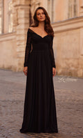 A woman stands on a cobblestone street in the La Femme 32722—an elegant long sleeve black formal dress.