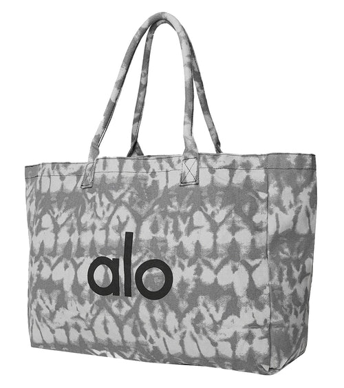Alo Yoga Mat Tote in Grey Tie-Dye design, featuring a spacious interior for yoga essentials. The tote is crafted for durability and style, perfect for carrying mats and accessories. Ideal for yoga enthusiasts seeking a fashionable and functional bag.